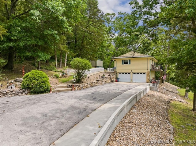 73 Good Neighbors Loop, Camdenton, MO 65020 - view of front of house featuring an attached garage, asphalt driveway, and view of wooded area