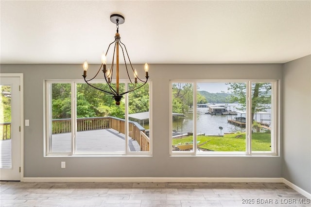 138 Siesta Cir, Camdenton, MO 65020 - unfurnished dining area featuring a water view, a chandelier, baseboards, and wood finished floors