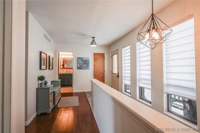 138 Siesta Cir, Camdenton, MO 65020 - corridor featuring a chandelier, baseboards, and dark wood-style flooring