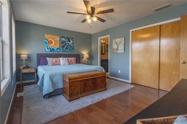 138 Siesta Cir, Camdenton, MO 65020 - bedroom with wood finished floors, ensuite bathroom, ceiling fan, baseboards, and a closet