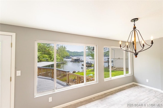 138 Siesta Cir, Camdenton, MO 65020 - unfurnished dining area featuring a water view, a chandelier, light wood finished floors, and healthy amount of natural light