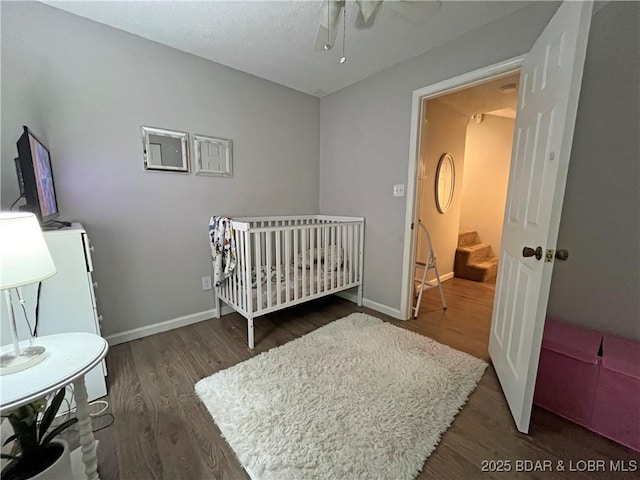 1130 Rachel Rd Unit 108, Osage Beach, MO 65065 - bedroom with wood finished floors, baseboards, ceiling fan, and a nursery area