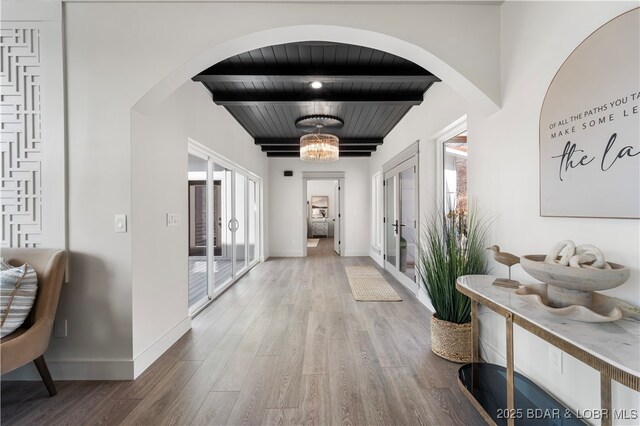 154 Via Cresta Dr, Sunrise Beach, MO 65079 - hallway featuring wood finished floors, arched walkways, french doors, baseboards, and wooden ceiling with exposed beams