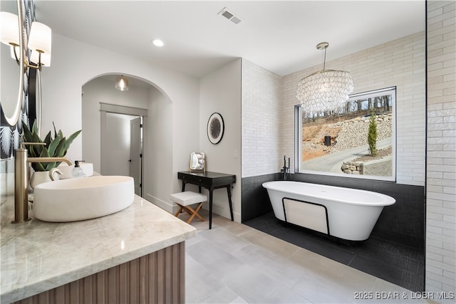154 Via Cresta Dr, Sunrise Beach, MO 65079 - bathroom featuring vanity, a chandelier, a soaking tub, recessed lighting, and tile walls