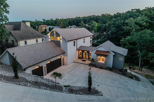 154 Via Cresta Dr, Sunrise Beach, MO 65079 - view of front of property featuring a garage, concrete driveway, stone siding, and stucco siding