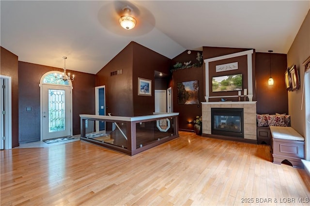 179 Regency Cove Dr, Lake Ozark, MO 65049 - foyer entrance featuring a chandelier, wood finished floors, a tile fireplace, and vaulted ceiling