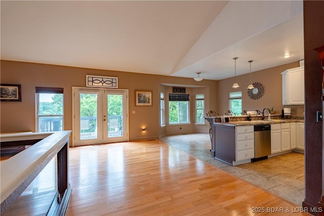 179 Regency Cove Dr, Lake Ozark, MO 65049 - kitchen with stainless steel dishwasher, a peninsula, white cabinets, hanging light fixtures, and lofted ceiling
