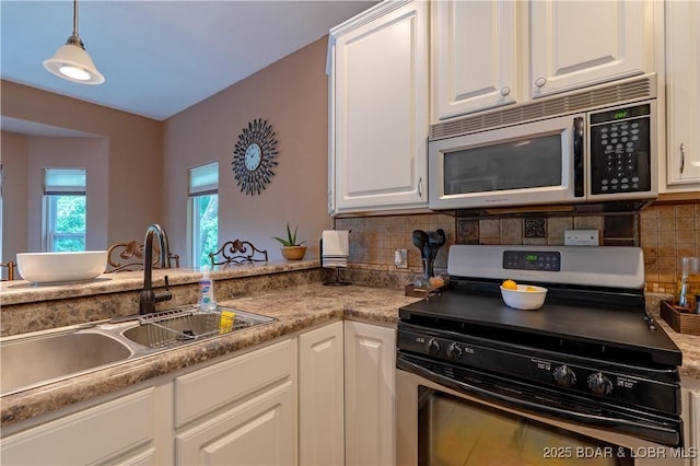 179 Regency Cove Dr, Lake Ozark, MO 65049 - kitchen with stainless steel appliances, a sink, backsplash, white cabinets, and hanging light fixtures