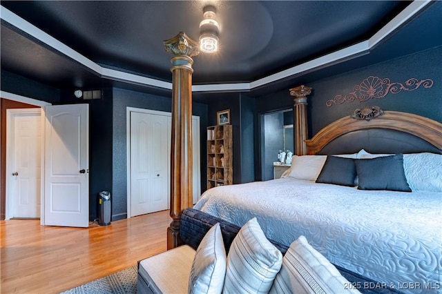 179 Regency Cove Dr, Lake Ozark, MO 65049 - bedroom featuring wood finished floors, a raised ceiling, a textured wall, and ceiling fan