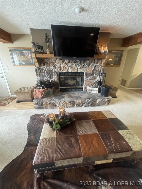 821 Winn Rd Unit 10D, Osage Beach, MO 65065 - carpeted living room with a textured ceiling and a stone fireplace