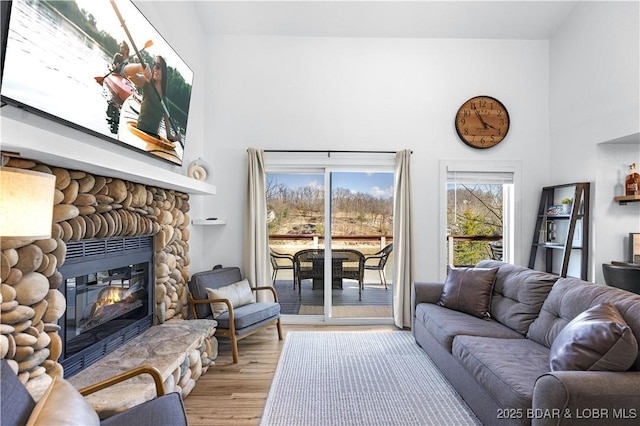 855 Ginger Rd, Lake Ozark, MO 65049 - living area with wood finished floors, a stone fireplace, and a towering ceiling