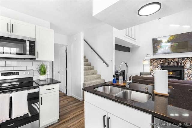 855 Ginger Rd, Lake Ozark, MO 65049 - kitchen featuring appliances with stainless steel finishes, a sink, wood finished floors, open floor plan, and white cabinets