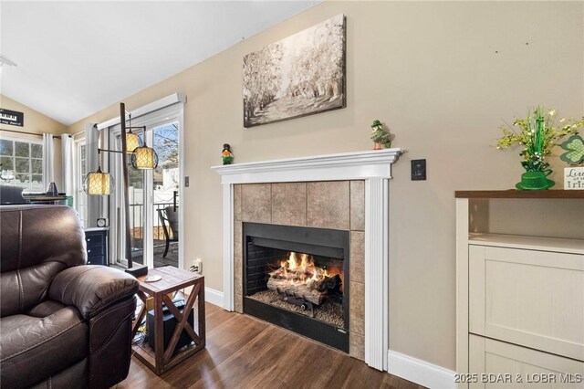 790 College Blvd, Osage Beach, MO 65065 - living room with dark wood finished floors, lofted ceiling, a tiled fireplace, plenty of natural light, and baseboards