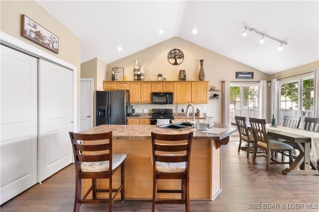 790 College Blvd, Osage Beach, MO 65065 - kitchen with black appliances, a sink, a kitchen bar, dark wood finished floors, and a center island with sink