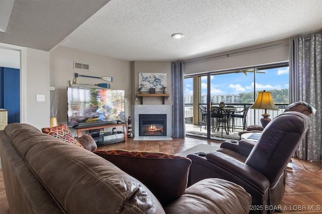 90 Falls Point Dr Unit 2C, Lake Ozark, MO 65049 - living area with tile patterned flooring, a warm lit fireplace, and a textured ceiling