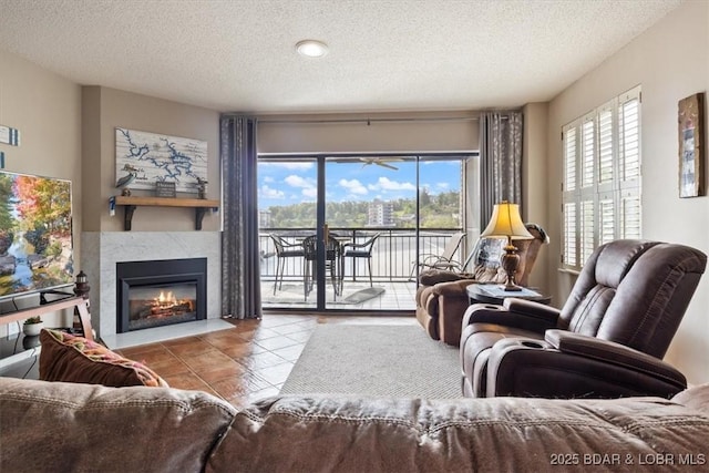 90 Falls Point Dr Unit 2C, Lake Ozark, MO 65049 - tiled living room featuring a textured ceiling, plenty of natural light, and a glass covered fireplace