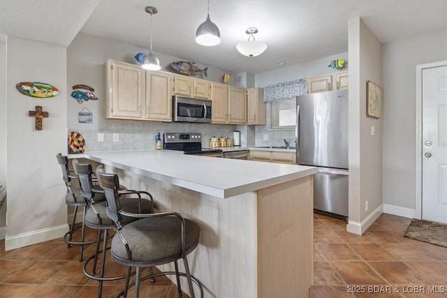 90 Falls Point Dr Unit 2C, Lake Ozark, MO 65049 - kitchen with stainless steel appliances, light brown cabinetry, decorative backsplash, light countertops, and a peninsula