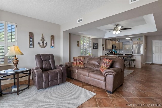 90 Falls Point Dr Unit 2C, Lake Ozark, MO 65049 - living room featuring a tray ceiling, ceiling fan, and baseboards