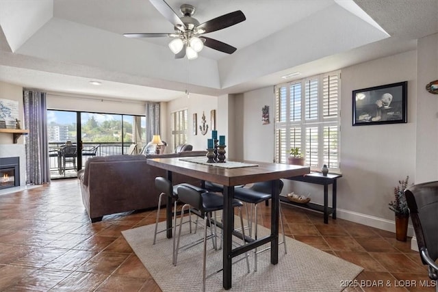 90 Falls Point Dr Unit 2C, Lake Ozark, MO 65049 - dining space with a ceiling fan, a glass covered fireplace, and baseboards