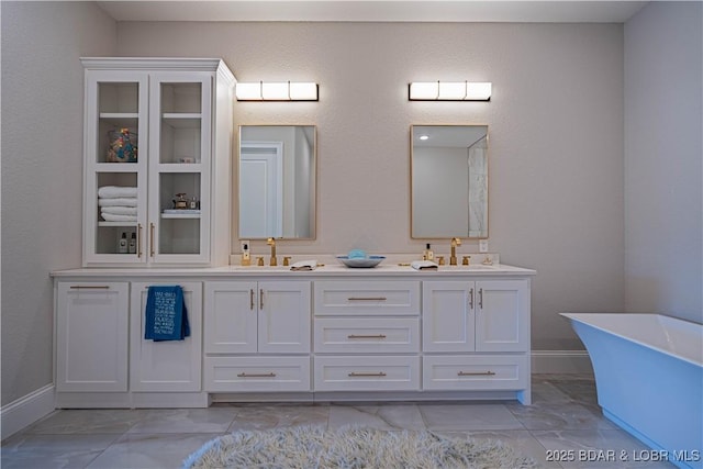 1184 Jeffries Rd Unit 310, Osage Beach, MO 65065 - bathroom featuring double vanity, a freestanding tub, marble finish flooring, and baseboards