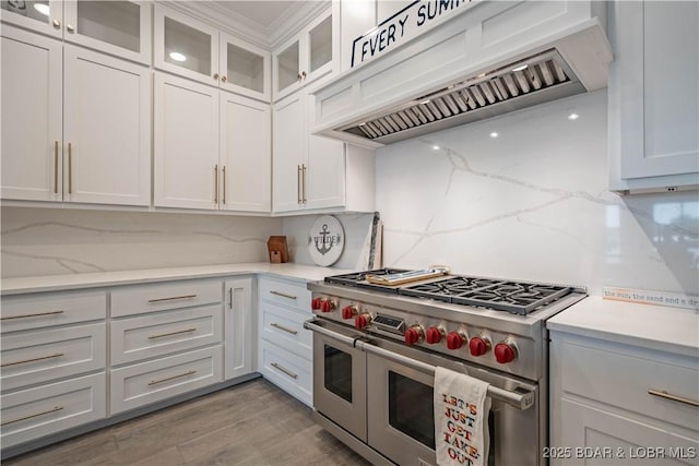 1184 Jeffries Rd Unit 310, Osage Beach, MO 65065 - kitchen featuring range with two ovens, custom range hood, backsplash, white cabinets, and glass insert cabinets