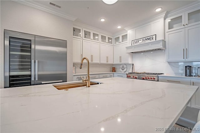 1184 Jeffries Rd Unit 310, Osage Beach, MO 65065 - kitchen featuring built in fridge, a sink, premium range hood, light stone counters, and ornamental molding