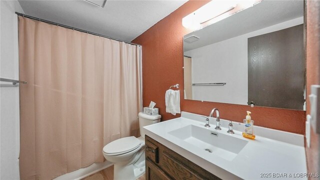 47 Dixie Ln, Sunrise Beach, MO 65079 - full bath featuring vanity, toilet, and a textured wall