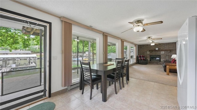 47 Dixie Ln, Sunrise Beach, MO 65079 - dining area with healthy amount of natural light, a ceiling fan, light colored carpet, light tile patterned floors, and a textured ceiling