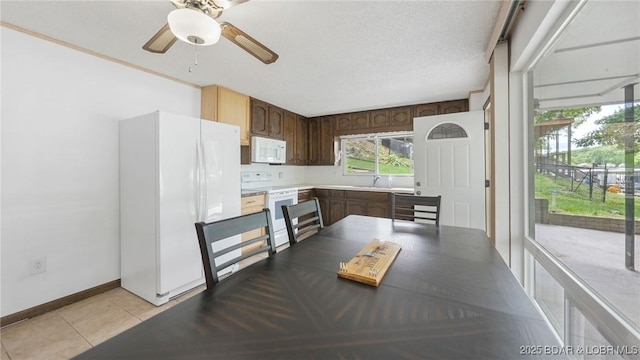 47 Dixie Ln, Sunrise Beach, MO 65079 - unfurnished dining area featuring light tile patterned floors, a ceiling fan, and baseboards