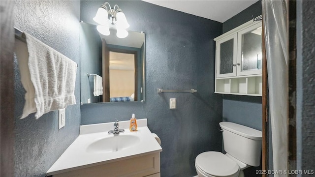 47 Dixie Ln, Sunrise Beach, MO 65079 - bathroom featuring a textured wall, toilet, and vanity