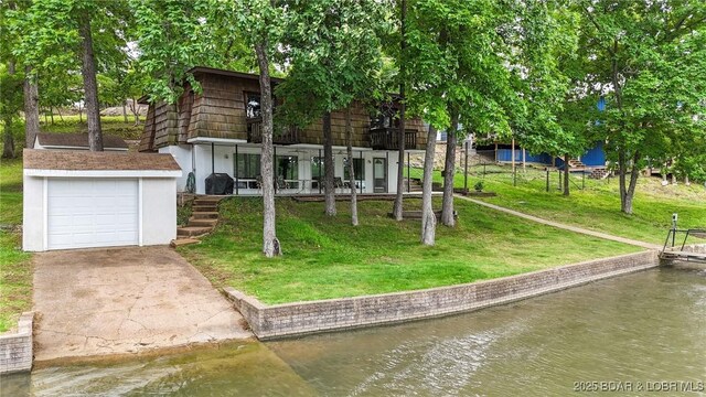 47 Dixie Ln, Sunrise Beach, MO 65079 - rear view of property with driveway, a water view, and a yard