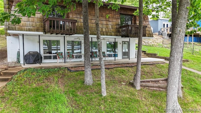47 Dixie Ln, Sunrise Beach, MO 65079 - back of house featuring a balcony, a patio area, and a lawn