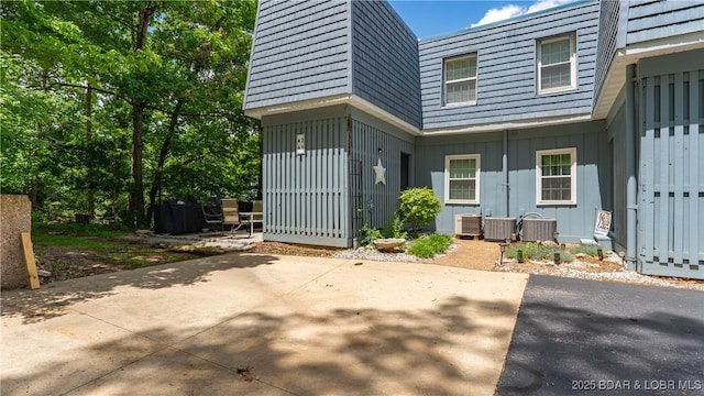 86 Henrys Way Unit 2A, Linn Creek, MO 65052 - doorway to property with board and batten siding, a patio, mansard roof, and central AC unit