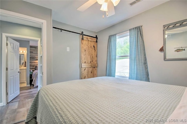 31806 Lakeview Ln, Gravois Mills, MO 65037 - bedroom with a barn door, wood finished floors, and ceiling fan