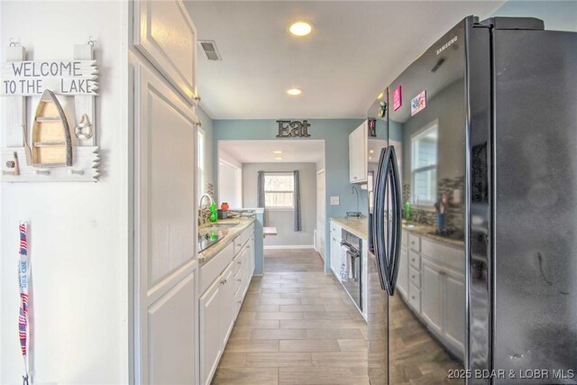 31806 Lakeview Ln, Gravois Mills, MO 65037 - kitchen with black appliances, recessed lighting, white cabinets, light wood-style floors, and light countertops