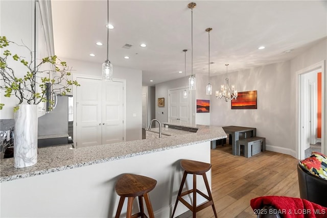 166 Captiva Dr Unit 8B, Sunrise Beach, MO 65079 - kitchen featuring wood finished floors, recessed lighting, a chandelier, baseboards, and a sink