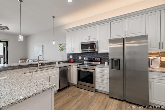 166 Captiva Dr Unit 8B, Sunrise Beach, MO 65079 - kitchen with appliances with stainless steel finishes, a sink, tasteful backsplash, light wood finished floors, and white cabinets
