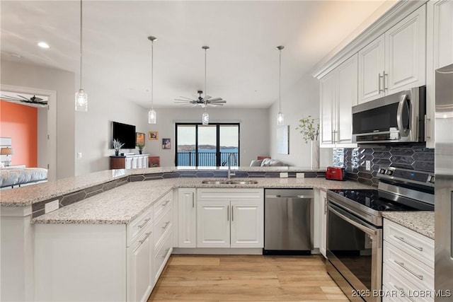 166 Captiva Dr Unit 8B, Sunrise Beach, MO 65079 - kitchen featuring appliances with stainless steel finishes, a sink, ceiling fan, a peninsula, and light wood finished floors