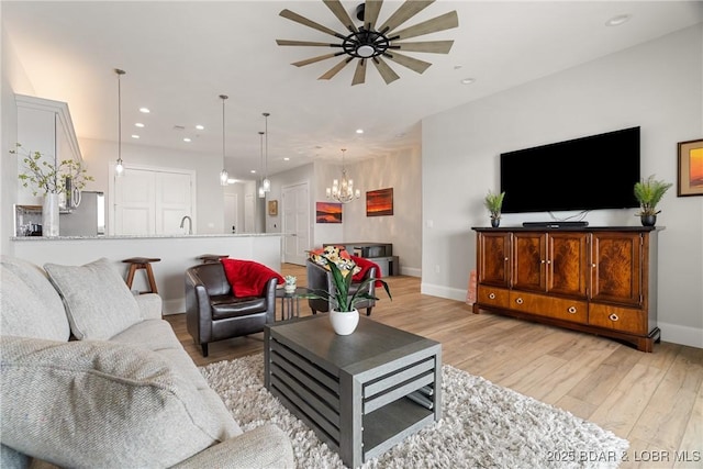 166 Captiva Dr Unit 8B, Sunrise Beach, MO 65079 - living room featuring a ceiling fan, a chandelier, baseboards, recessed lighting, and light wood-type flooring