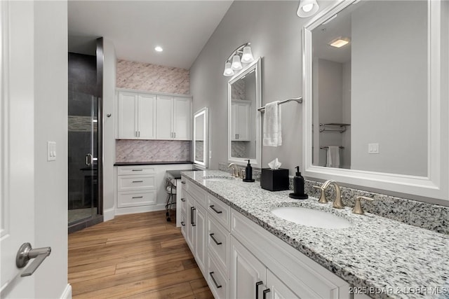 166 Captiva Dr Unit 8B, Sunrise Beach, MO 65079 - bathroom featuring double vanity, a shower stall, wood finished floors, and recessed lighting