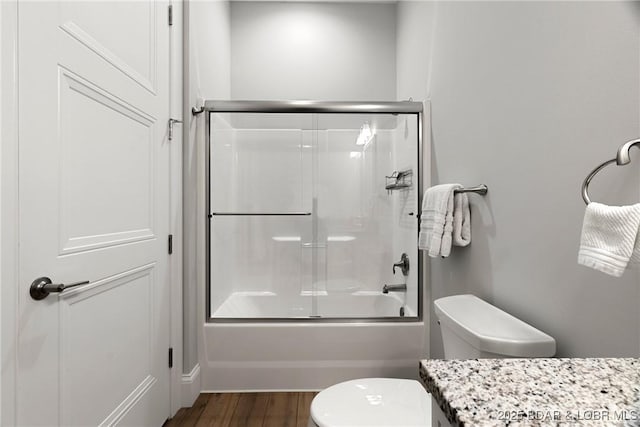 166 Captiva Dr Unit 8B, Sunrise Beach, MO 65079 - bathroom featuring toilet, vanity, wood finished floors, and bath / shower combo with glass door
