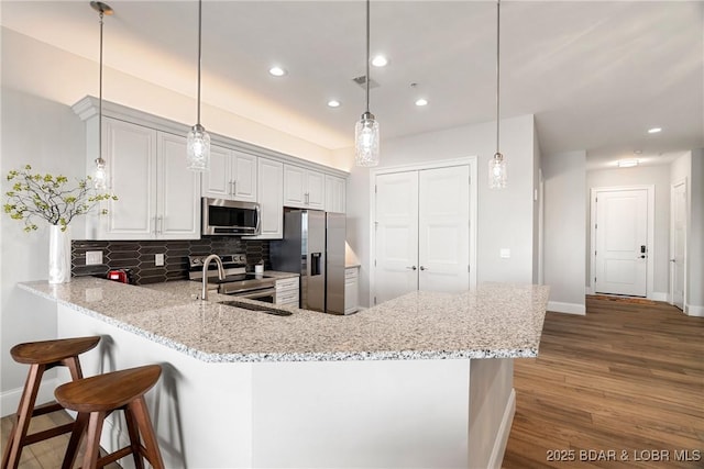 166 Captiva Dr Unit 8B, Sunrise Beach, MO 65079 - kitchen with appliances with stainless steel finishes, a sink, baseboards, decorative backsplash, and recessed lighting