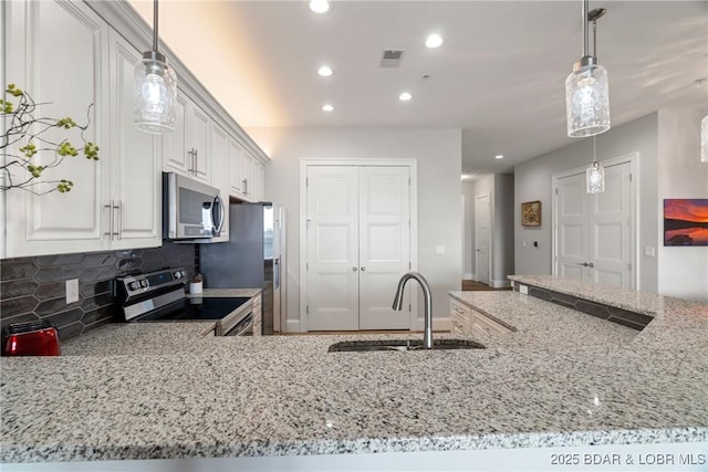 166 Captiva Dr Unit 8B, Sunrise Beach, MO 65079 - kitchen with appliances with stainless steel finishes, a sink, light stone counters, decorative backsplash, and recessed lighting