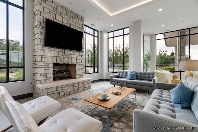 166 Captiva Dr Unit 8B, Sunrise Beach, MO 65079 - living room featuring baseboards, healthy amount of natural light, a fireplace, a wall of windows, and recessed lighting