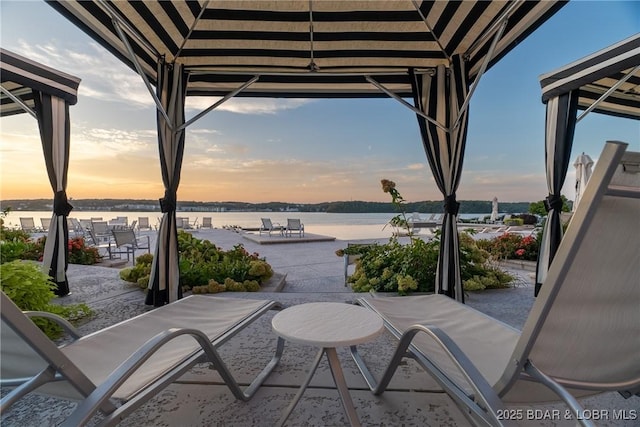 166 Captiva Dr Unit 8B, Sunrise Beach, MO 65079 - balcony at dusk with a patio, a water view, and a sunroom