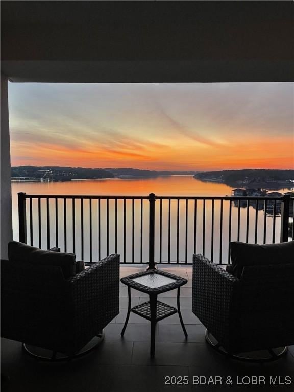 166 Captiva Dr Unit 8B, Sunrise Beach, MO 65079 - balcony at dusk featuring a water view