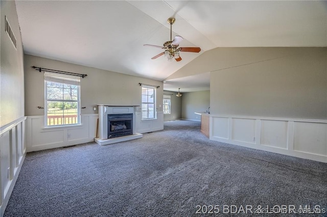 20715 Hiltner Ln, Saint Robert, MO 65584 - unfurnished living room featuring vaulted ceiling, ceiling fan, a decorative wall, carpet floors, and wainscoting