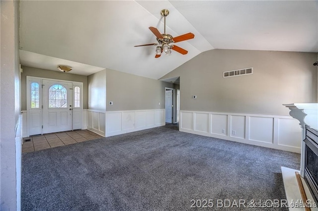 20715 Hiltner Ln, Saint Robert, MO 65584 - unfurnished living room with carpet flooring, a ceiling fan, a decorative wall, a wainscoted wall, and vaulted ceiling