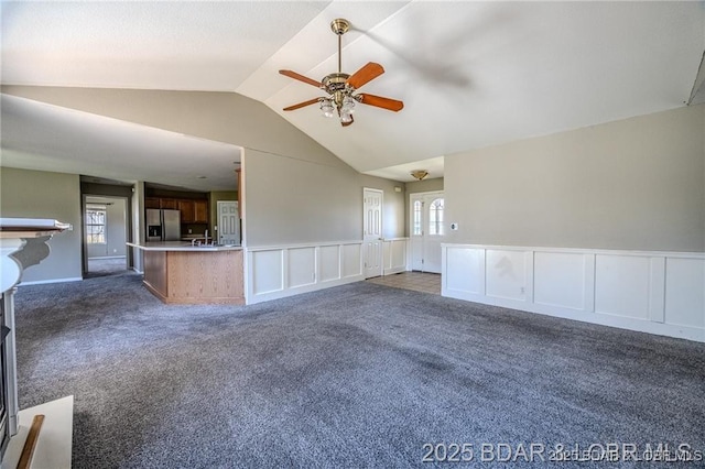 20715 Hiltner Ln, Saint Robert, MO 65584 - unfurnished living room with dark colored carpet, lofted ceiling, ceiling fan, a wainscoted wall, and a decorative wall