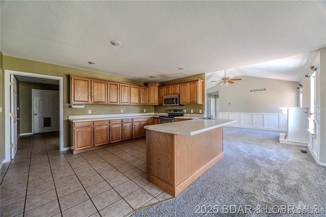 20715 Hiltner Ln, Saint Robert, MO 65584 - kitchen with appliances with stainless steel finishes, light countertops, a sink, wainscoting, and ceiling fan